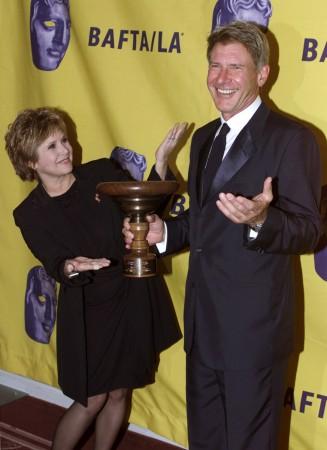 Actor Harrison Ford (R) and actress Carrie Fisher pose with the Stanley Kubrick Britannia Award for Excellence in Film, during the 11th annual BAFTA/LA Britannia Awards in Los Angeles, California on April 12, 2002 Carrie Fisher and Harrison Ford