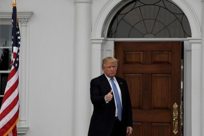 U.S. President-elect Donald Trump gestures from the front door at the main clubhouse at Trump National Golf Club in Bedminster, New Jersey, U.S., November 20, 2016. Donald Trump