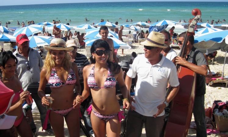 Cubans dance to live music on a beach on the outskirts of Havana September 1, 2012. Cuba's beaches are an attraction for tourists the world over, whether they are foreigners paying thousands of dollars to reach them, or Cubans paying as little as five dollars for a three-day vacation in a seaside cabin. fidel castro obama economy cuban tourism beaches loved ones Caribbean islands peso diplomatic relations war cold war russia ussr satellite cuban missile crisis soviet russia