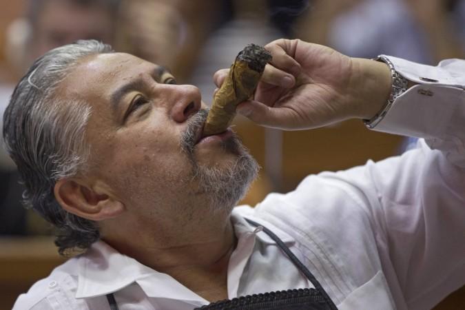 A cigar enthusiast smokes a cigar made by himself at a rolling lesson during the XVII Habanos Festival in Havana, February 25, 2015. Cuban cigar-maker Habanos S.A. envisions gaining 25 percent to 30 percent of the U.S. premium cigar market if the United States lifts its trade embargo on Cuba, potentially selling 70 million to 90 million cigars per year, the company said. fidel castro obama economy cuban tourism beaches loved ones Caribbean islands peso diplomatic relations war cold war russia ussr satellite cuban missile crisis soviet russia