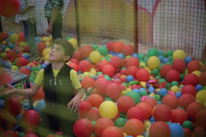 In picture: A child plays in the ball court at the Land of Childhood. The playground receives up to 400 children a day during holiday periods. Syria