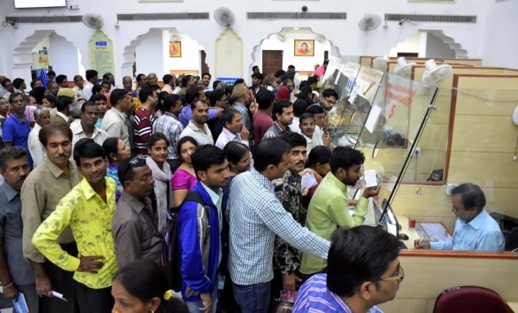 People queue at a bank branch to exchange demonetised notes in Jaipur on Nov. 12, 2016. Estimates that about 20 percent of the demonetised Rs 500 and Rs 1,000 notes won't come back to the system seem unrealistic, given that reports suggest Rs 11 lakh crore out of Rs 14 lakh crore has already been brought back to the banking system. demonetisation gamble modi sarkar government deposits bank notes exchange rbi black money cash