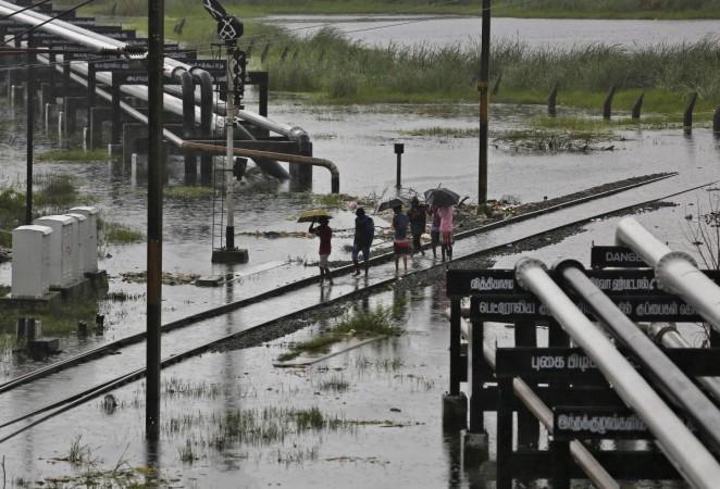 People walk on a flooded railway track as it rains in Chennai, India, December 6, 2015. Tamil Nadu J Jayalalithaa Assembly polls elections health apollo hospital cardiac arrest industry growth gsdp factories ford hyundai renault ashok leyland