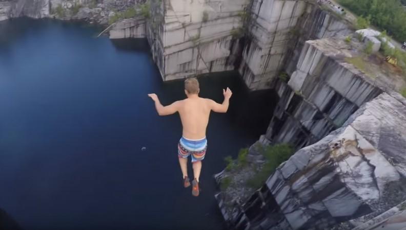 A man taking a cliff jumping stunt