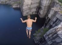A man taking a cliff jumping stunt
