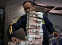 A bank employee stacks banned Rs 1,000 notes.