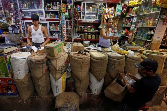 A shopkeeper sells groceries to a customer at his shop in Kolkata, India, September 12, 2016. retail inflation, inflation may 2017, iip april 2017