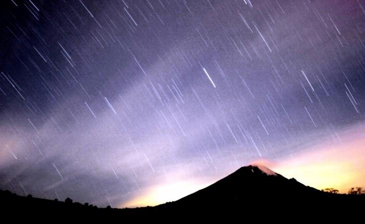 A meteor shower lights up the sky over the Mexican volcano Popocatepetl near the village San Nicolas de los Ranchos in Mexican state of Puebla in the early hours of December 14, 2004. The shower, named Geminid because it appears to originate from the constellation Gemini, lit up the sky with dozens of shooting stars per hour. Geminid meteor shower