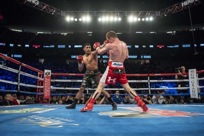 Amir Khan (maroon shorts) punches Canelo Alvarez (red shorts) during their middleweight boxing title fight at T-Mobile Arena in May 2016 amir khan boxer