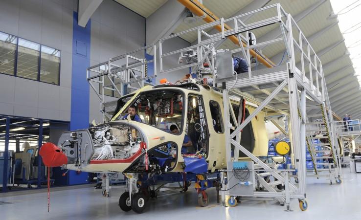 An AgustaWestland employee works on a helicopter at their headquaters in Vergiate, northern Italy, March 13, 2015. agustawestland india deal aw101 congress bjp debate lok sabha rajya sabha scam bribe
