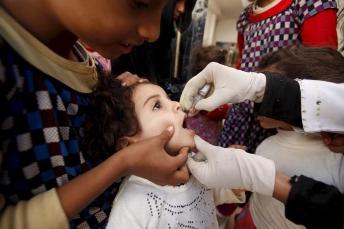 This image portrays a girl receiving polio vaccination outside her house in Yemen's capital Sanaa. Though this disease can be prevented by vaccines, there is no cure for this ailment yet. Polio