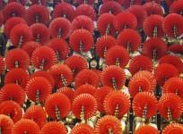 A girl laughs as she sits among hand fans during a mass performance at a children's martial arts fair in Foshan, Guangdong province