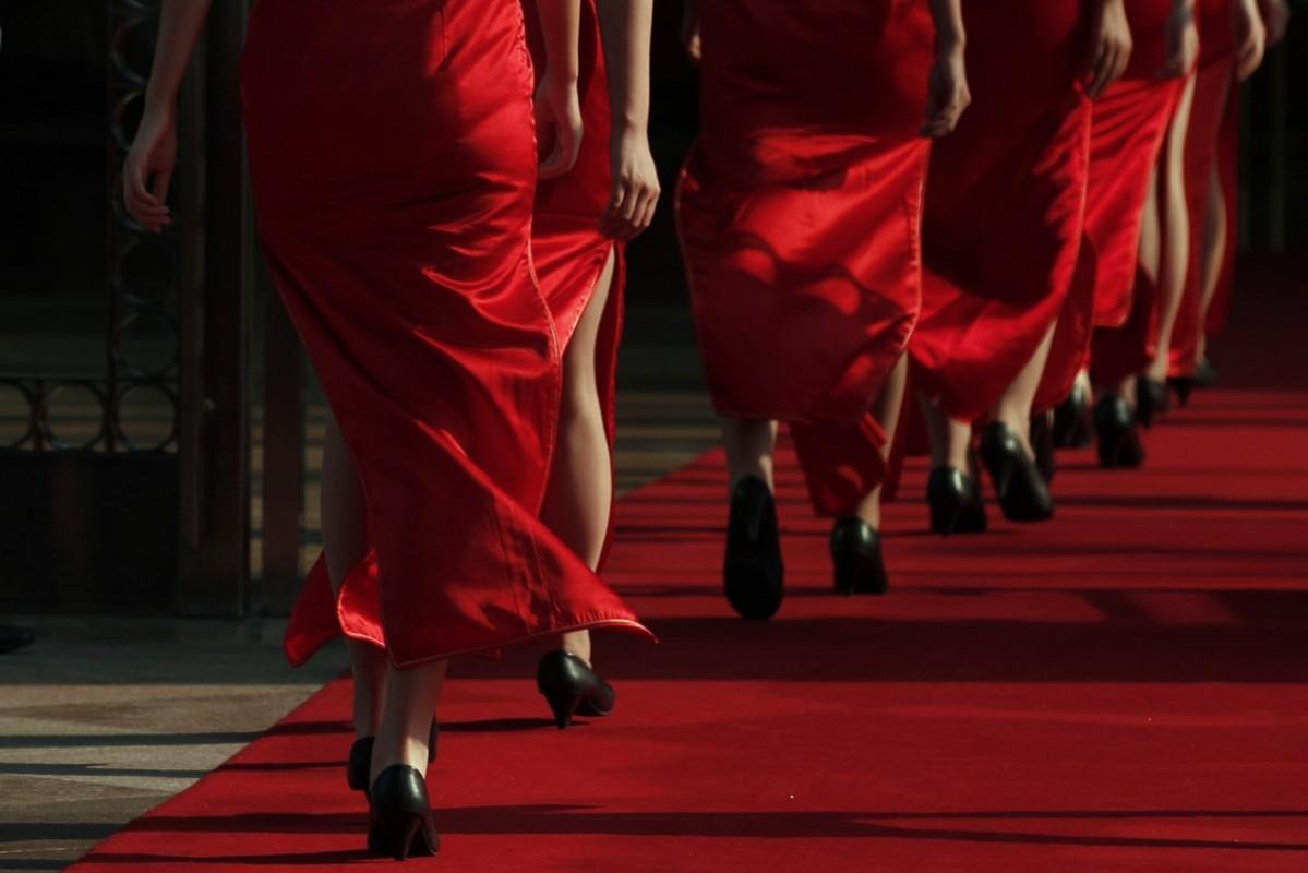 Hotel guides dressed in elegant red ahead of a conference in China Hotel guides walk at a entrance to the BFA Hotel during the Boao Forum for the 2013 Asia annual conference in Boao town, Hainan province
