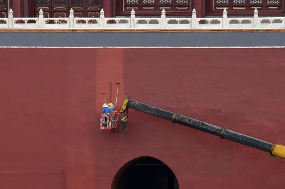 Workers paint a red wall of the Forbidden City in central Beijing, China Workers paint a red wall of the Forbidden City in central Beijing