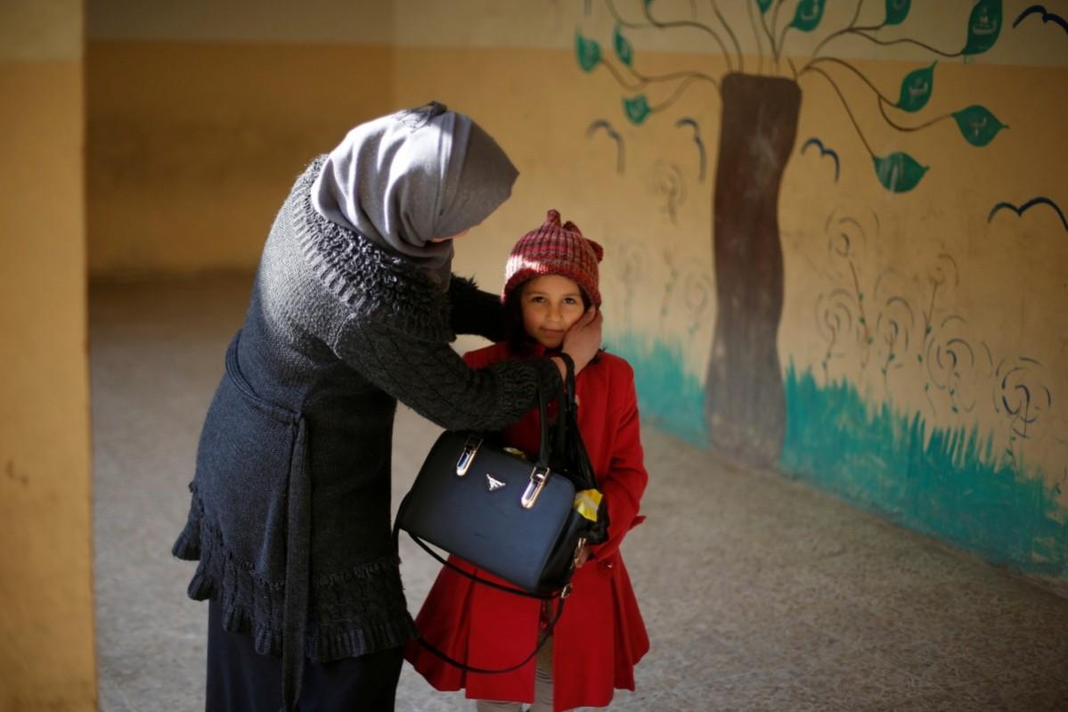A mother adjusts her daughter's hat before she enters a classroom in school in Mosul. Girls were forbidden from going to school under ISIS extremist rule for two years until U.S.-backed Iraqi forces recaptured most eastern districts of the city and are preparing to push into the western part of Mosul, the largest city held by Islamic State across its self-proclaimed caliphate in Iraq and Syria. An ISIS-scarred child gets ready to return to school in east Mosul, Iraq