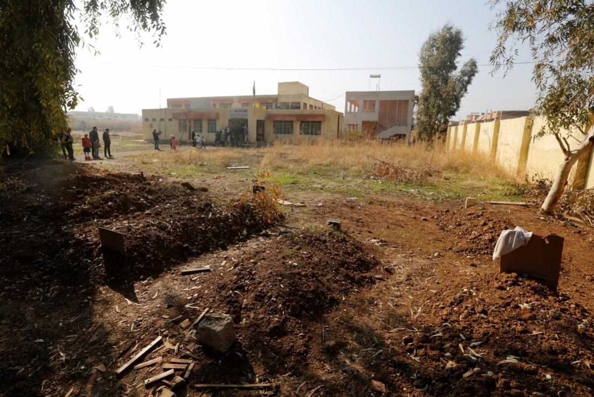 Fresh graves in a school compound in east Mosul, Iraq. One schoolyard in the area has been turned into a cemetery covered with dozens of freshly dug graves, leaving no open space for children to play. ISIS-affected children return to school in east Mosul, Iraq