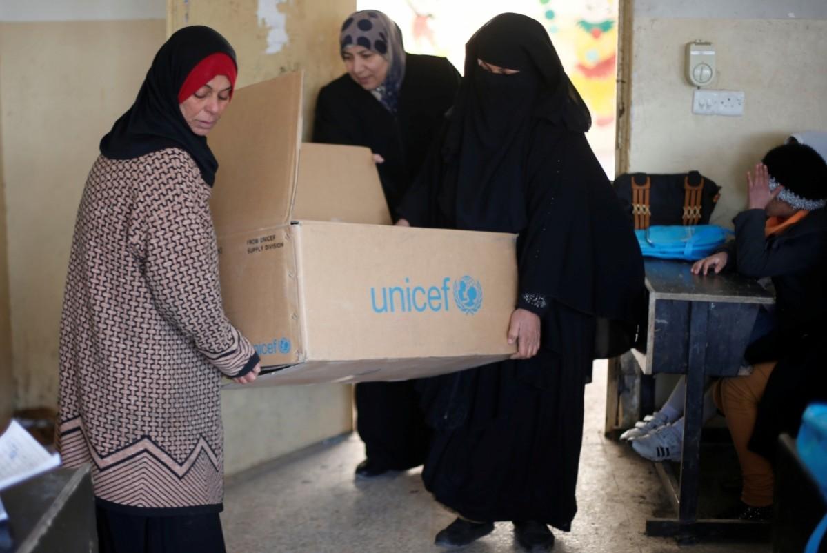 Teachers carry boxes with new school bags for students who are registering in a school in east Mosul that has reopened after US-led forces defeated the ISIS ISIS-affected children return to school in east Mosul, Iraq