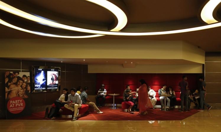 Cinema-goers wait at the lobby of a PVR Multiplex in Mumbai November 10, 2013. pvr screens, pvr multiplex, inox multiplex, multiplex association of india, protest against cap on cinema ticket prices, karnataka govt