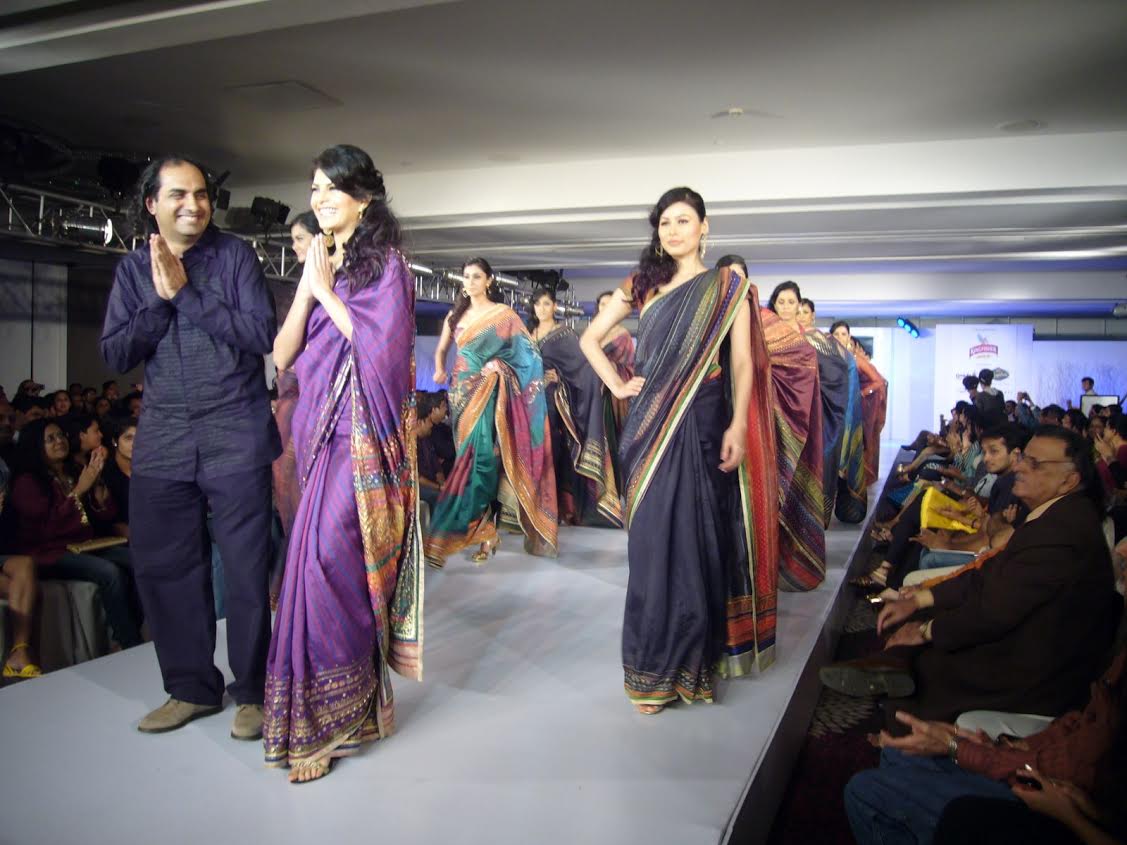 Model-actor Jacqueline Fernandez and designer Satya Paul at the Chennai International Fashion Week in 2009. satya paul, genesis colors, genesis ipo, genesis colors listing, genesis colors promoters, genesis colors price band