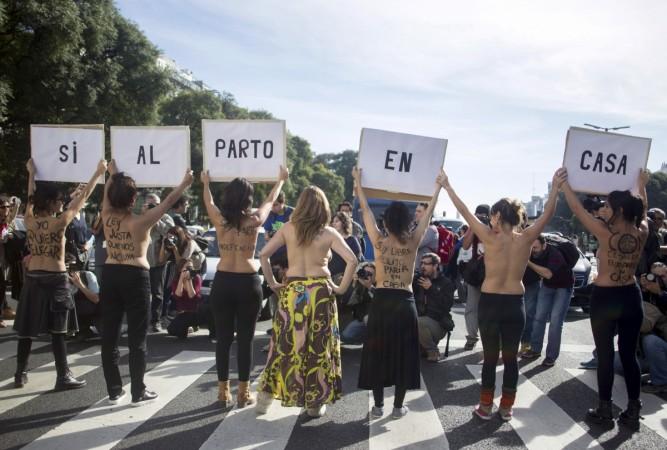 A group of midwives hold placards forming the phrase Argentina protests