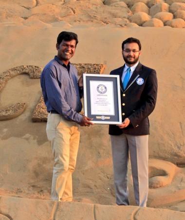 Sand artist Sudarshan Pattnaik (left) is given the official confirmation from Guinness World Records for creating the largest sand castle in the world. Sudarshan Pattnaik