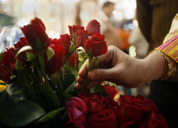 A woman selects roses from a flower shop ahead of Valentine's Day celebrations in the eastern Indian city of Kolkata February 13, 2008 (representational image). valentine's day, valentine's day 2017, roses, rose exporters, valentine's day greetings, valentine's day messages, india flower exports, hosur, columbia, trump protectionism
