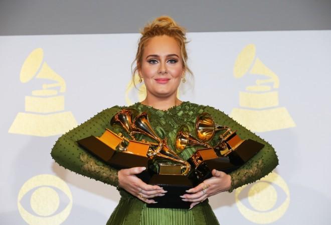 Adele holding five Grammys she won this year. Adele grammys 2017