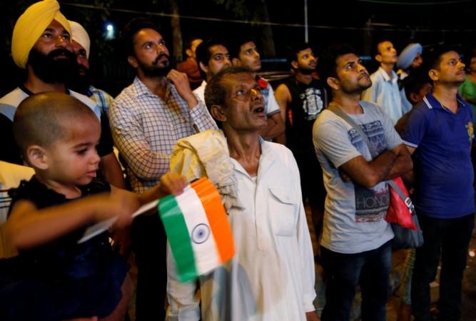 People watch the Rio Olympics final badminton match between India's P.V. Sindhu and Carolina Marin of Spain on a screen in Chandigarh, India, August 19, 2016 groupm report, groupm adex report, tyny report, This Year Next Year, indian ad industry, india ad agencies