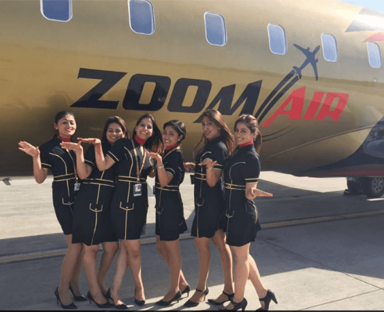 Air hostess posing before a Zoom Air aircraft. zoom air, indian civil aviation market, dgca, zoom air destinations, zoom air management, zoom air ceo, zoo air fare