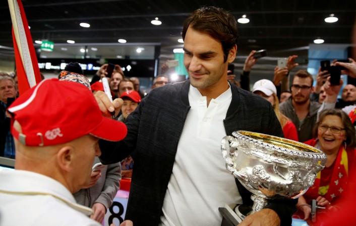 Switzerland's Roger Federer holds his Australian Open trophy as he signs a fans' cap upon his arrival at Zurich airport January 31, 2017. kraft heinz news, 3g capital, gisele bundchen, kraft heinz bids for unilever, kraft heinz bids $143 billion for, 3g capital kraft heinz, fmcg company unilever