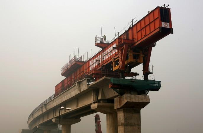 A worker works at the construction site of a bridge being built over the Yamuna river for metro rail on a smoggy morning in New Delhi, India, November 2, 2016. india gdp growth, india second cso estimate for fy2017, india q3 gdp growth, indian economy, demonetisation, modi govt, pm modi