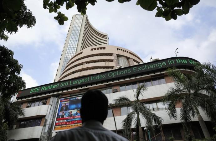 A man looks at a screen across the road on the facade of the Bombay Stock Exchange (BSE) building in Mumbai May 16, 2014. sensex at all time high, sensex at new high, indian stock markets, djia at record high, djia makes history