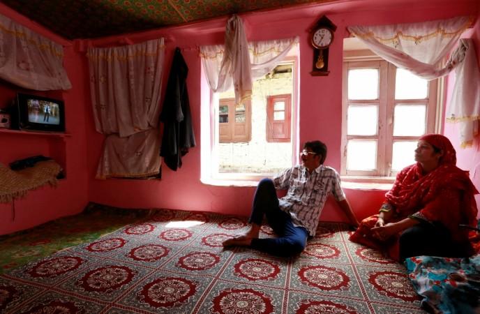 Members of a family watch television in their home in Srinagar as the city remains under curfew following weeks of violence in Kashmir, August 21, 2016. television viewership in india, tv viewership in india, barc india suvey, bi survey, tv serials in india, tv ads in india