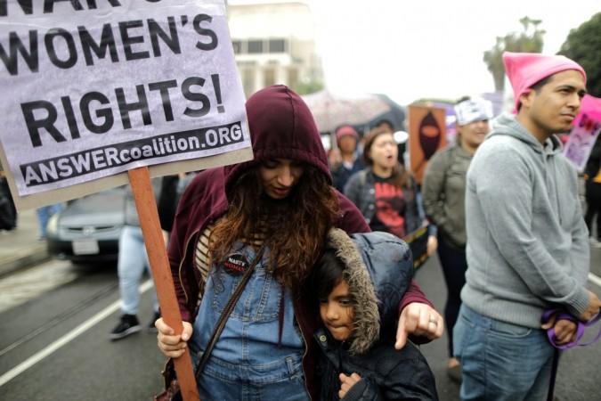 People attend a rally in the rain for International Women's Day in Los Angeles, California, U.S., March 5, 2017. International Women's Day
