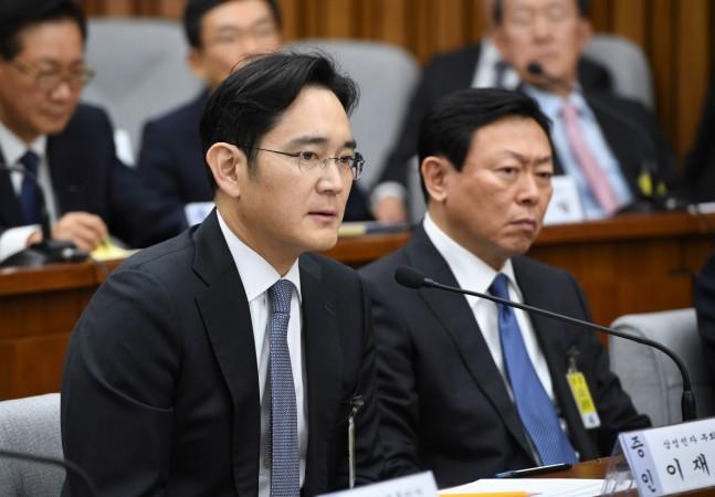 Samsung Group's heir-apparent Lee Jae-yong (L) answers a question as Lotte Group Chairman Shin Dong-Bin (R) listens during a parliamentary probe into a scandal engulfing President Park Geun-Hye at the National Assembly in Seoul on December 6, 2016. samsung scandal, President Park Geun-hye impeachment, samsung heir apparent Lee Jae-yong, corporate scandals in south korea