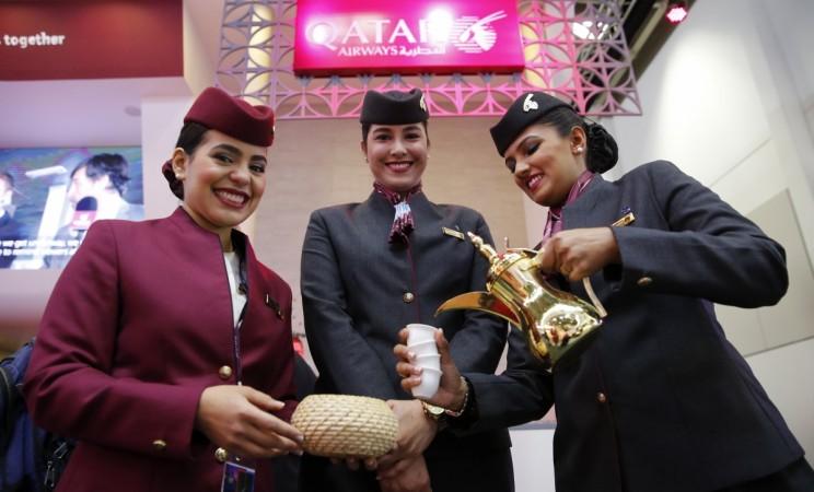 Qatar Airways flight attendants pose at the exhibition stand of the company at the International Tourism Trade Fair (ITB) in Berlin, Germany, March 9, 2016. qatar airways, qatar airways new airline in india, fdi norms for civil aviation in india, india civil aviation market, emirates, gulf air, spicejet
