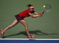 Sania Mirza of India chases down a return with playing partner Martina Hingis of Switzerland (not pictured) as they face Casey Dellacqua of Australia and Yaroslava Shvedova of Kazakhstan in the women's doubles final match at the U.S. Open Championships te