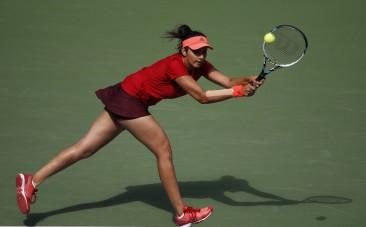 Sania Mirza of India chases down a return with playing partner Martina Hingis of Switzerland (not pictured) as they face Casey Dellacqua of Australia and Yaroslava Shvedova of Kazakhstan in the women's doubles final match at the U.S. Open Championships te