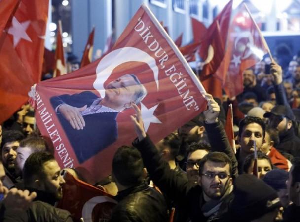 Demonstrators with banners of Turkish President Recep Tayyip Erdogan gather outsidethe Turkish consulate in Netherlands. Turkish demonstrators