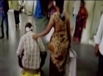 Raju pushing around on his son's tricycle while his wife Santoshi helps him