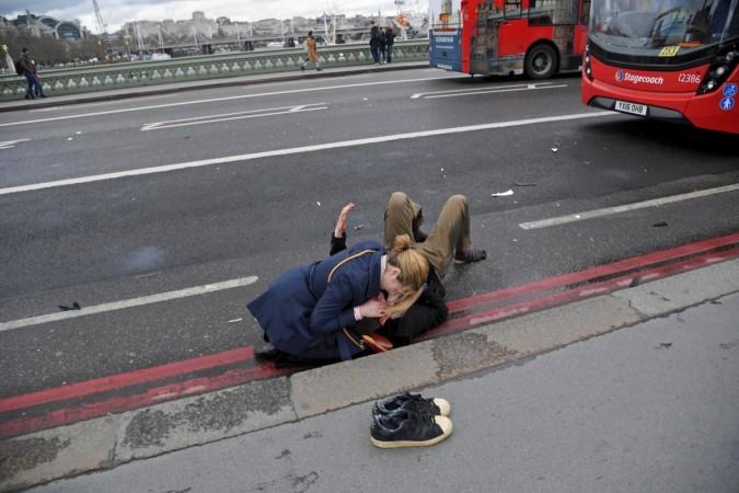 A woman assists an injured person after the attack on Westminster Bridge in London Westminster attack