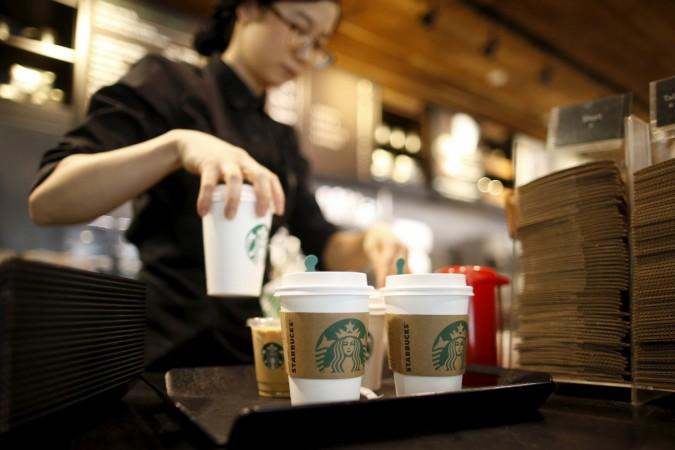 A staff serves beverages at a Starbucks coffee shop in Seoul, South Korea, March 7, 2016. starbucks, starbuck stores, starbucks jobs, hiring by starbucks