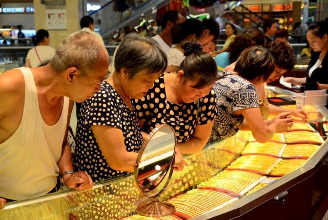 Customers look at gold necklaces at a jewelry store in Xuchang, Henan province, August 12, 2015. gold, china, Shandong Gold Group, Laizhou Zhaoyuan region of china, gold demand in china