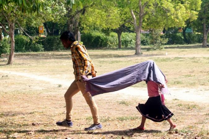 A girl cover her face as she walk on a Delhi road on a hot sunny day, on April 1, 2017. heat wave, hot temperature, rising temperature, hot conditions, temperature soaring, summer, sun stroke, weather, climate