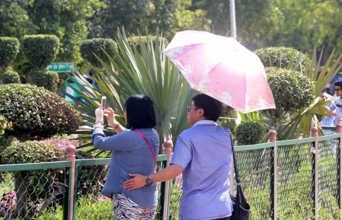 A man use umbrella to shield him from scorching sun on a hot day in New Delhi on April 1, 2017. heat wave, hot temperature, rising temperature, hot conditions, temperature soaring, summer, sun stroke, weather, climate, tourism, fta, foreign tourists in india