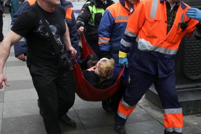 An injured person is helped by emergency services outside Sennaya Ploshchad metro station in St. St Petersburg blast