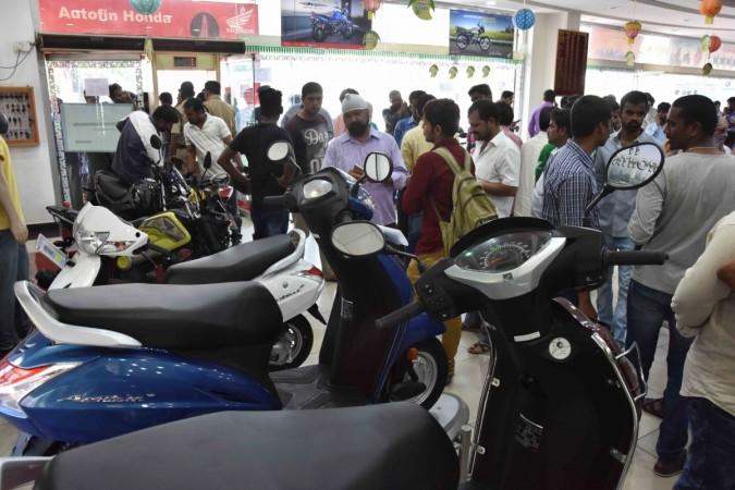 People in large numbers at a 2 Wheeler showroom to buy discounted vehicles after the BS III vehicles ban on sale and registration of vehicles from 1st April 2017 and the vehicles which do not meet the new standards, in Hyderabad on March 31, 2017. bs iii vehicles, bs 3, discount on scooters, discount on motorcycles, domestic auto sales, scooter sales, motorcycle sales, bs iii discount