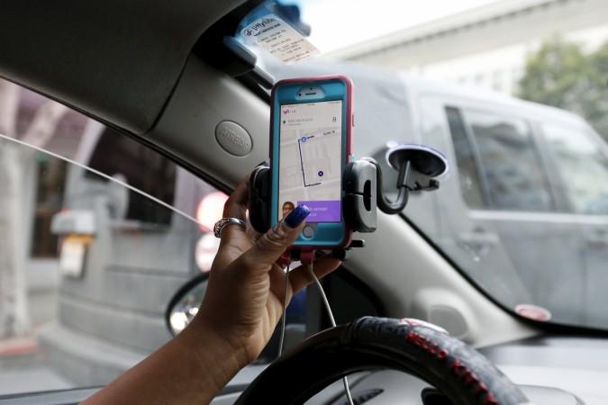 Maya Jackson, a Lyft driver from Sacramento, responds to a ride request on her smartphone during a photo opportunity in San Francisco, California February 3, 2016. lyft, lyft valuation, cab hailing company lyft, lyft raises $500 million, uber rival lyft, uber valuation, ola valuation, cab hailing app grab