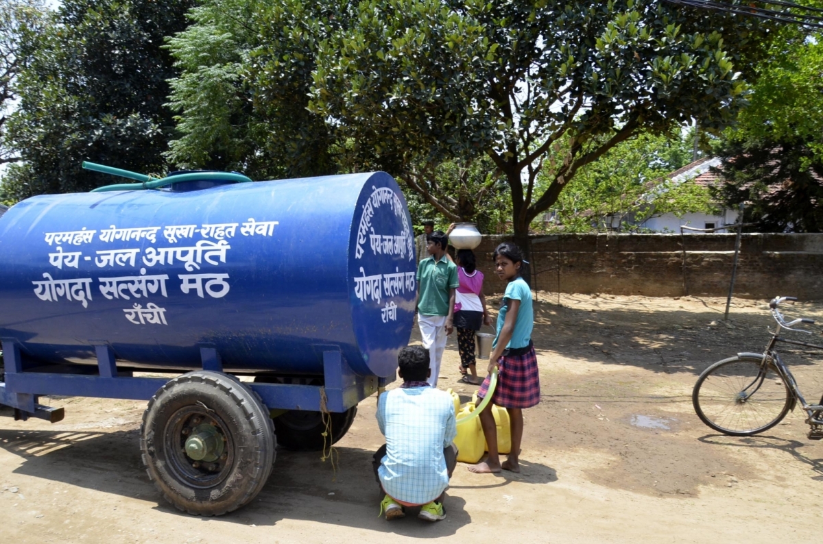 People fill their jerry cans from a water tanker sent by Yogoda Satsanga Math to a drought hit village on the outskirts of Ranchi on May 12, 2016. drought, water tankers, water scarcity, water crisis, indian farmers, agri loans, bank loans, farm loans, waiver
