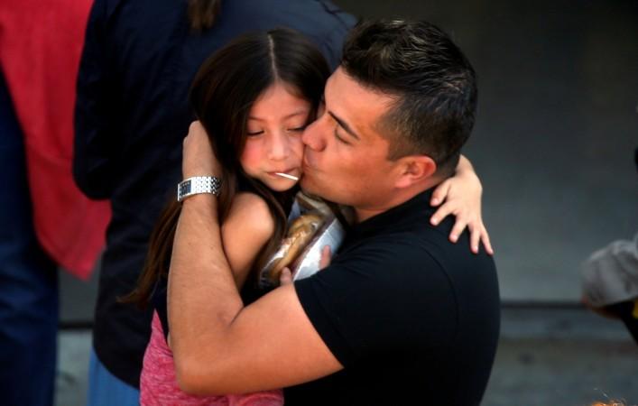 A student who was evacuated after a shooting at North Park Elementary School is embraced after groups of them were reunited with parents waiting at a high school in San Bernardino, California, U.S. April 10, 2017. San bernardino school shooting